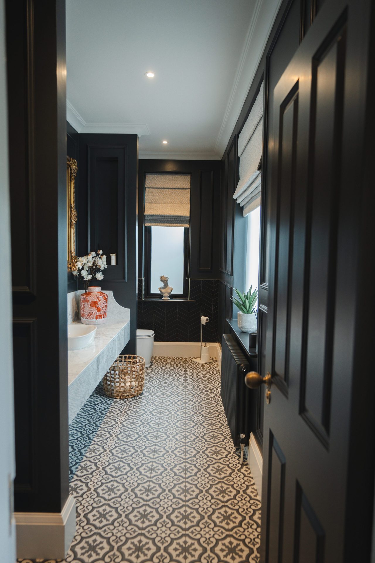 The W.C seen from the doorway, the patterned tile running the length of the room