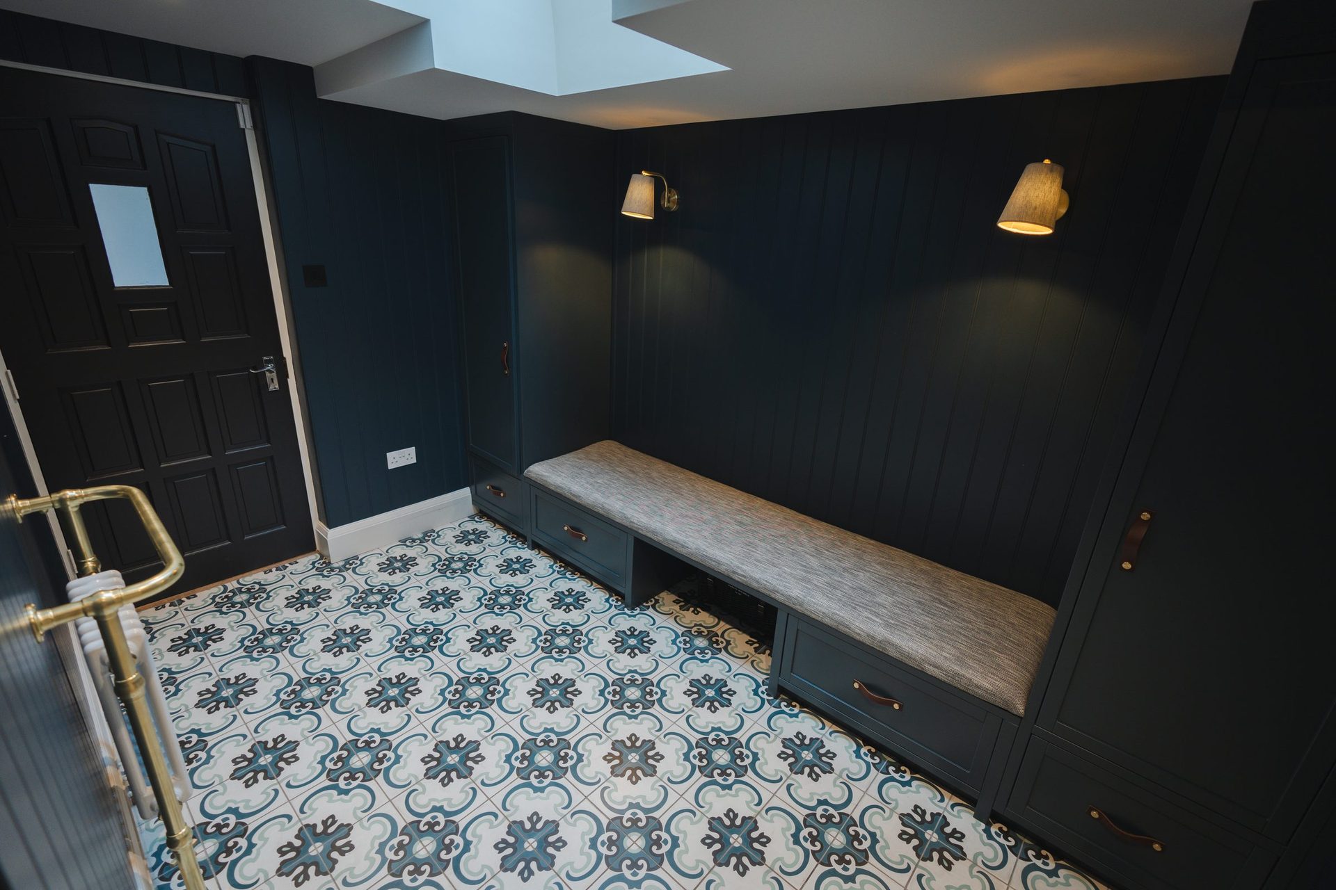 The back lobby, dark panelled walls, patterned encaustic tile floor carried through from the W.C, built-in bench for coats and boots