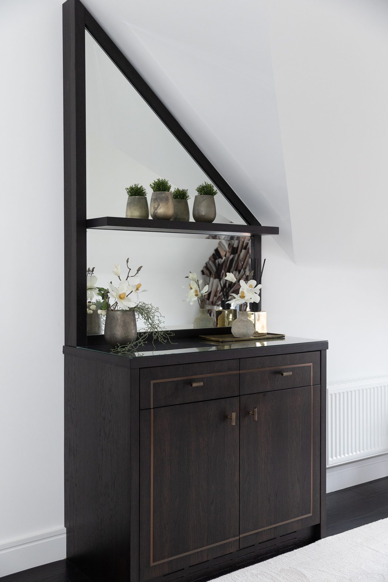 Pewter pots and magnolias against the dressing mirror in the Sycamore master suite