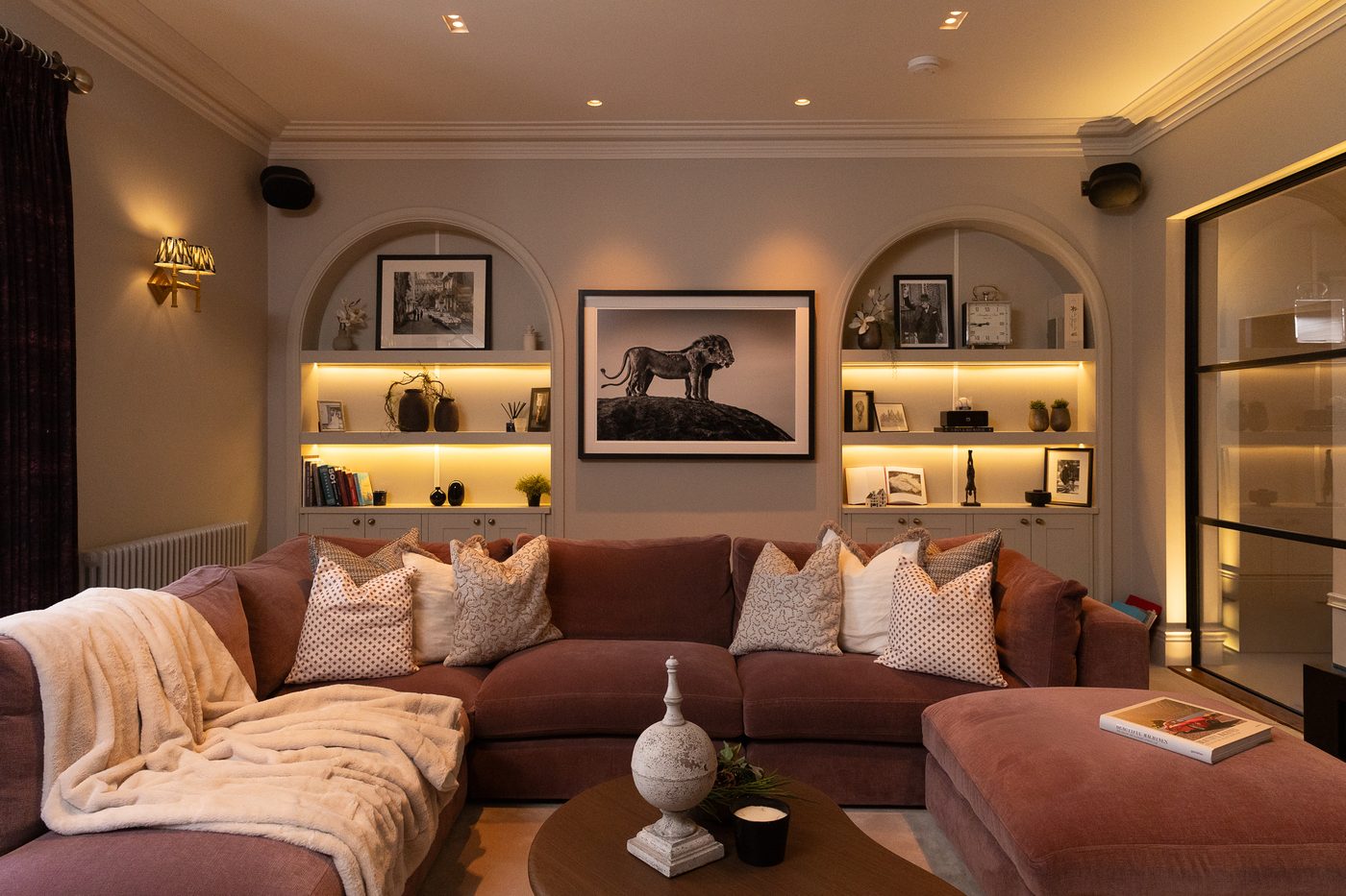 Lamp-lit living room with arched alcoves and layered textiles